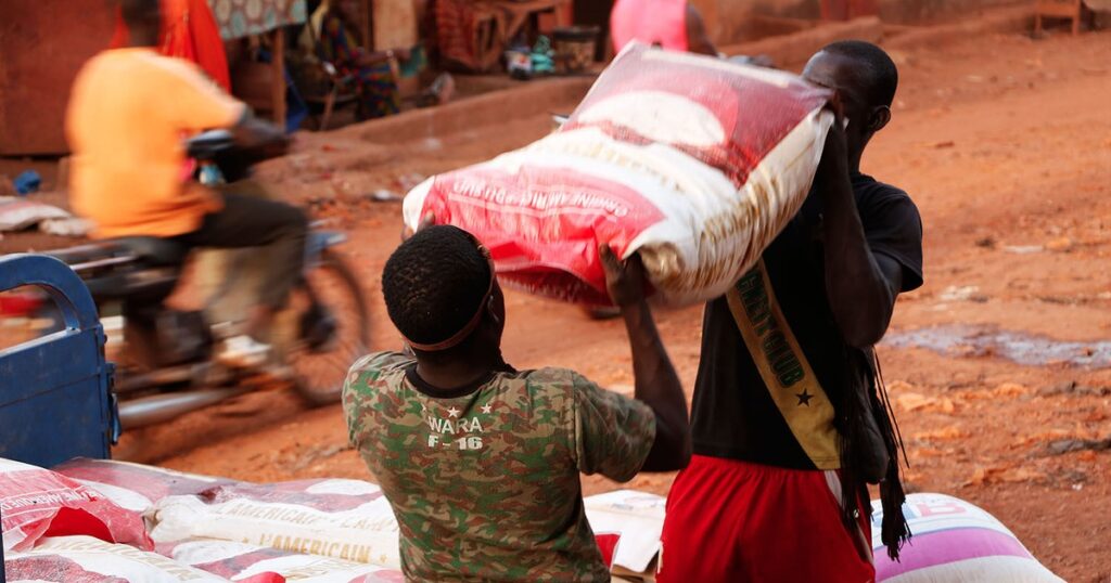 Dechargement de sacs de riz sur un marche ouest-africain, alors que la faim menace 55 millions de personnes en Afrique de l'Ouest