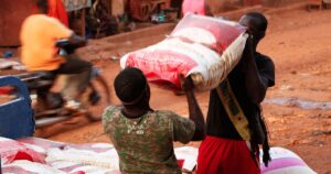 Dechargement de sacs de riz sur un marche ouest-africain, alors que la faim menace 55 millions de personnes en Afrique de l'Ouest