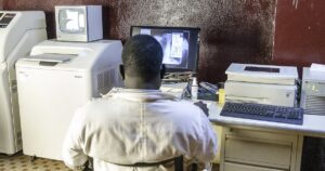 Agent de sante devant un ecran d'imagerie medicale au Burkina Faso, illustrant les donnees sur les personnels soignants