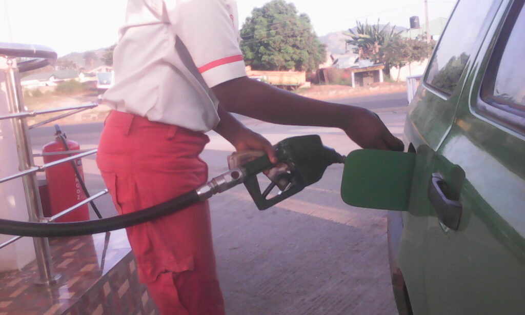 Pompiste remplissant le réservoir d'un véhicule, illustration des prix des carburants en Afrique