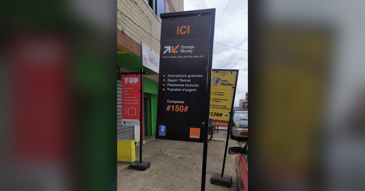 Enseignes Orange Money, MTN MoMo et YUP devant un point de mobile money au Cameroun, secteur que la COBAC surveille