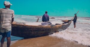 Pêcheurs artisanaux et leur pirogue chargée de filets sur la plage d'Ikuru, une côte exposée à la pêche illégale au Nigeria