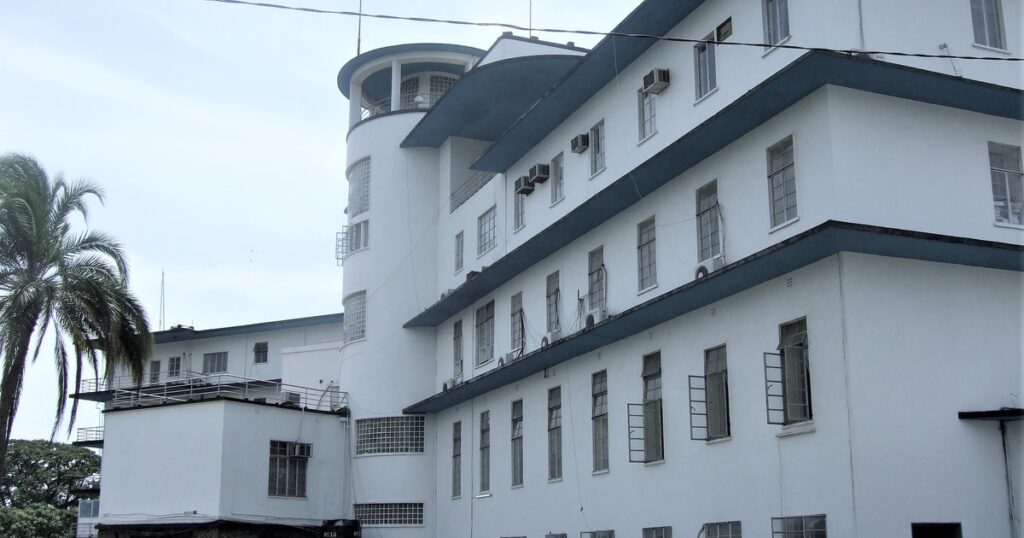 Façade blanche du State House à Freetown, siège du président de la Sierra Leone, avec voitures garées devant