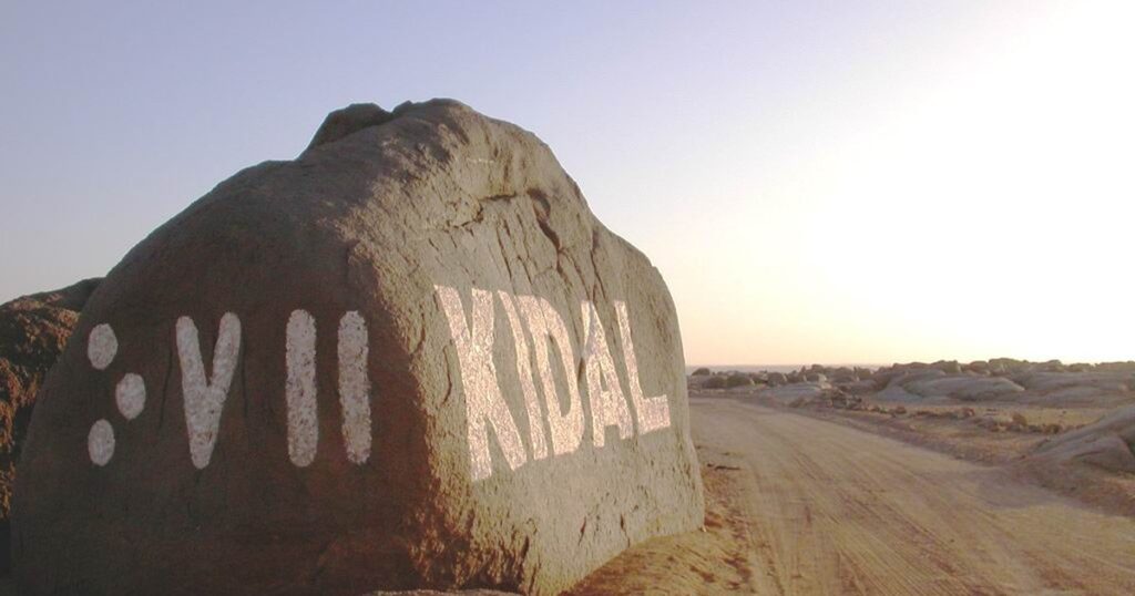 Rocher marqué Kidal en tifinagh et en lettres latines à l'entrée de la ville de Kidal, au Mali